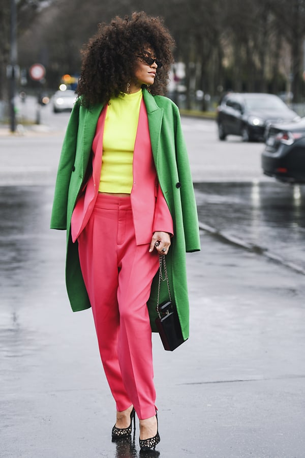 woman in coral, yellow and green outfit showing eclectic style